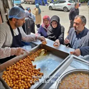 Pendik Lokma Döktürme Hayır Lokmacısı Pendik'te lokma hizmeti; araç üzerinde usta lokma yapıyor, insanlar sırada lokma alıp dua ediyor.